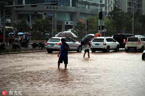 南山區路人走在馬路上，積水已經到小腿中部